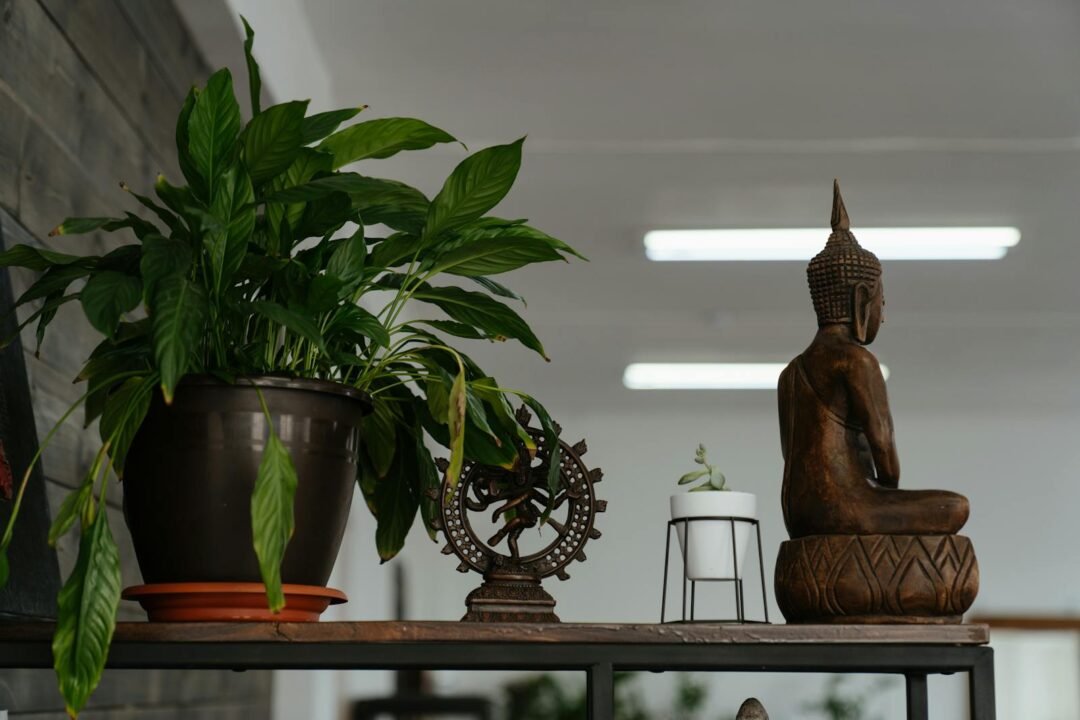 Cómo Crear un Espacio de Meditación en Casa: Ideas para Crear un Ambiente Zen 3 A Buddha sculpture and lush indoor plants enhance the serenity of a calming workspace.