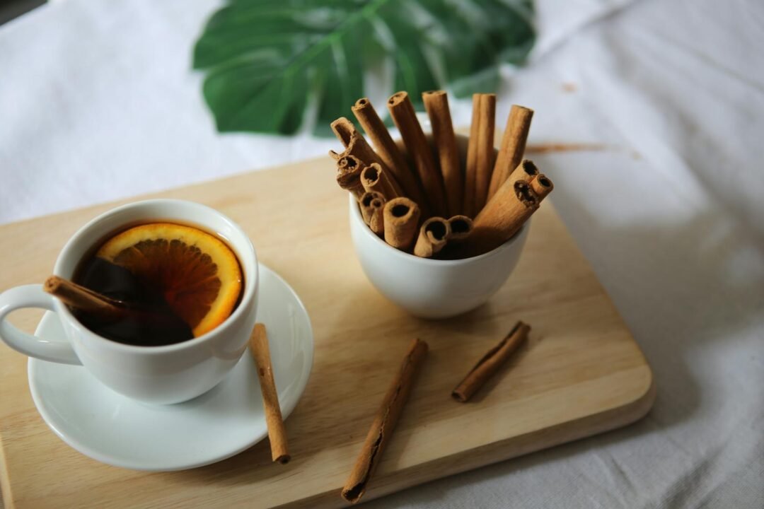 5 ideas para convertir tu rutina de baño en un spa en casa 5 Cozy setup with cinnamon sticks and warm orange tea on a wooden surface.