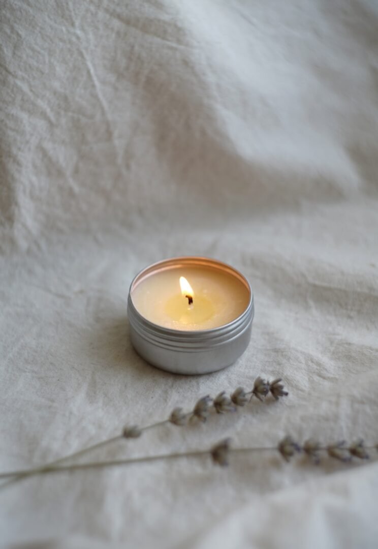 a soya candle sitting on top of a white sheet
